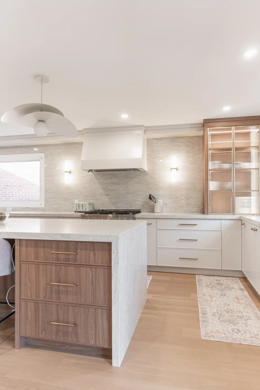 Interior of a Thornhill detached house renovation, with white cabinetry, light oak millwork, and a pale stone counter.