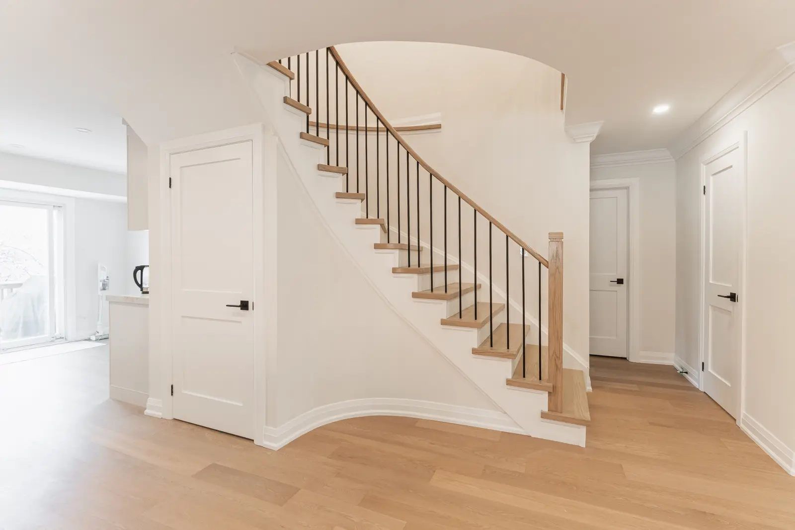 Interior of a Thornhill detached house renovation, with white cabinetry, light oak millwork, and a pale stone counter.