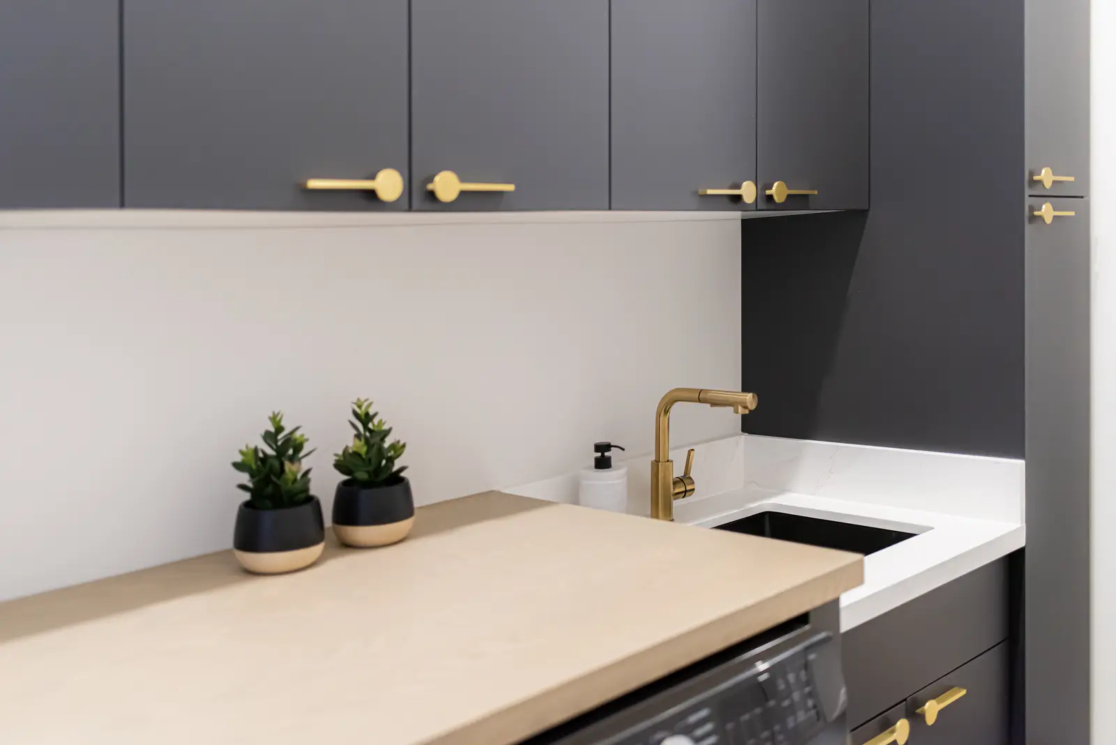 Interior of a Thornhill detached house renovation, with pale wood floors, black furnishings, and a walnut vanity in the primary bathroom.