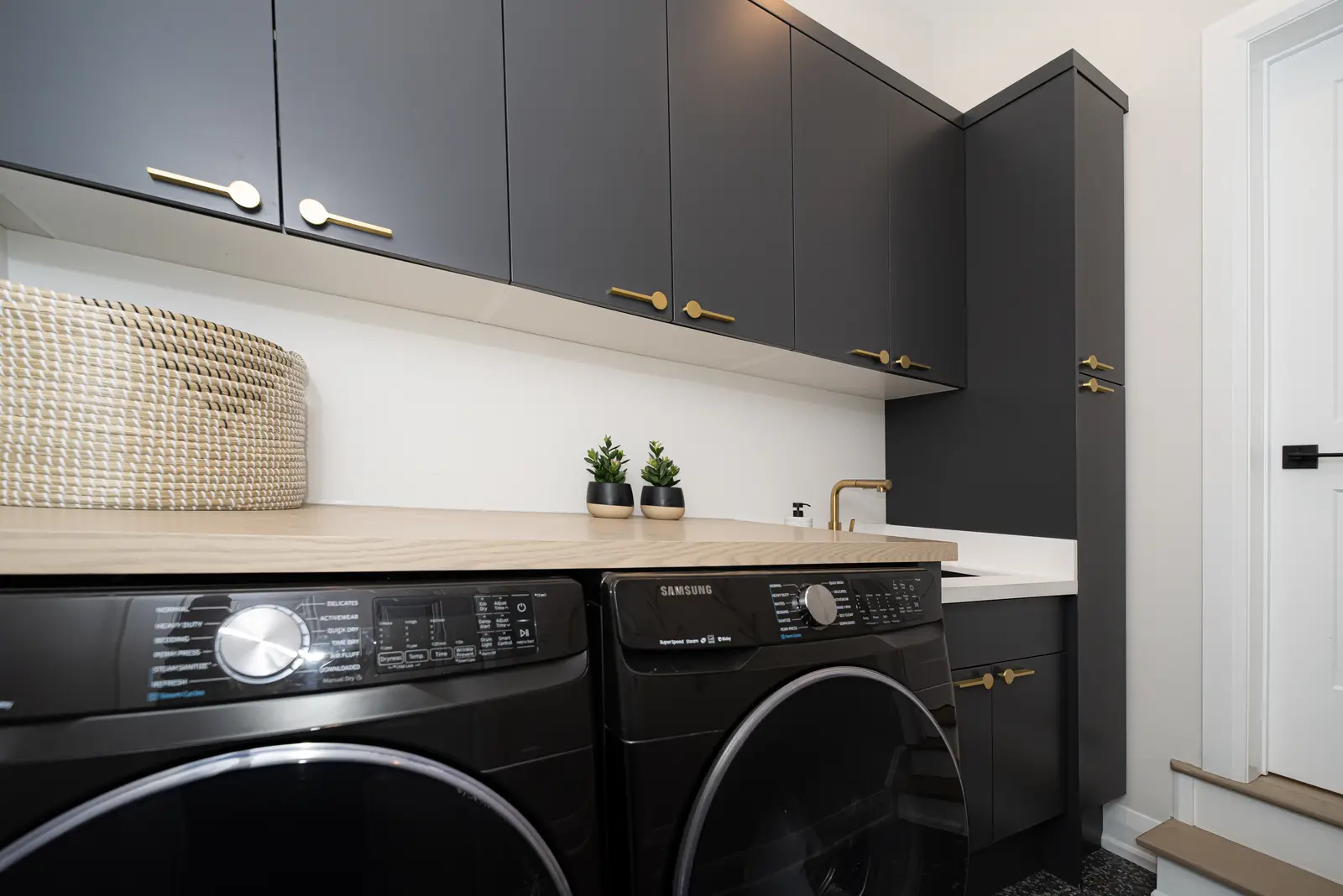 Interior of a Thornhill detached house renovation, with pale wood floors, black furnishings, and a walnut vanity in the primary bathroom.
