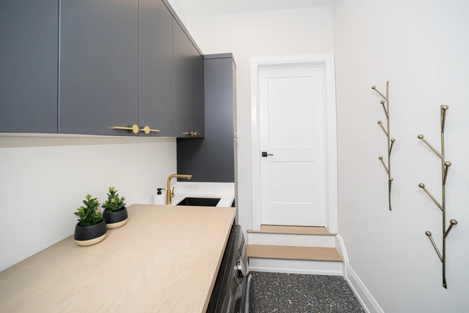 Interior of a Thornhill detached house renovation, with pale wood floors, black furnishings, and a walnut vanity in the primary bathroom.