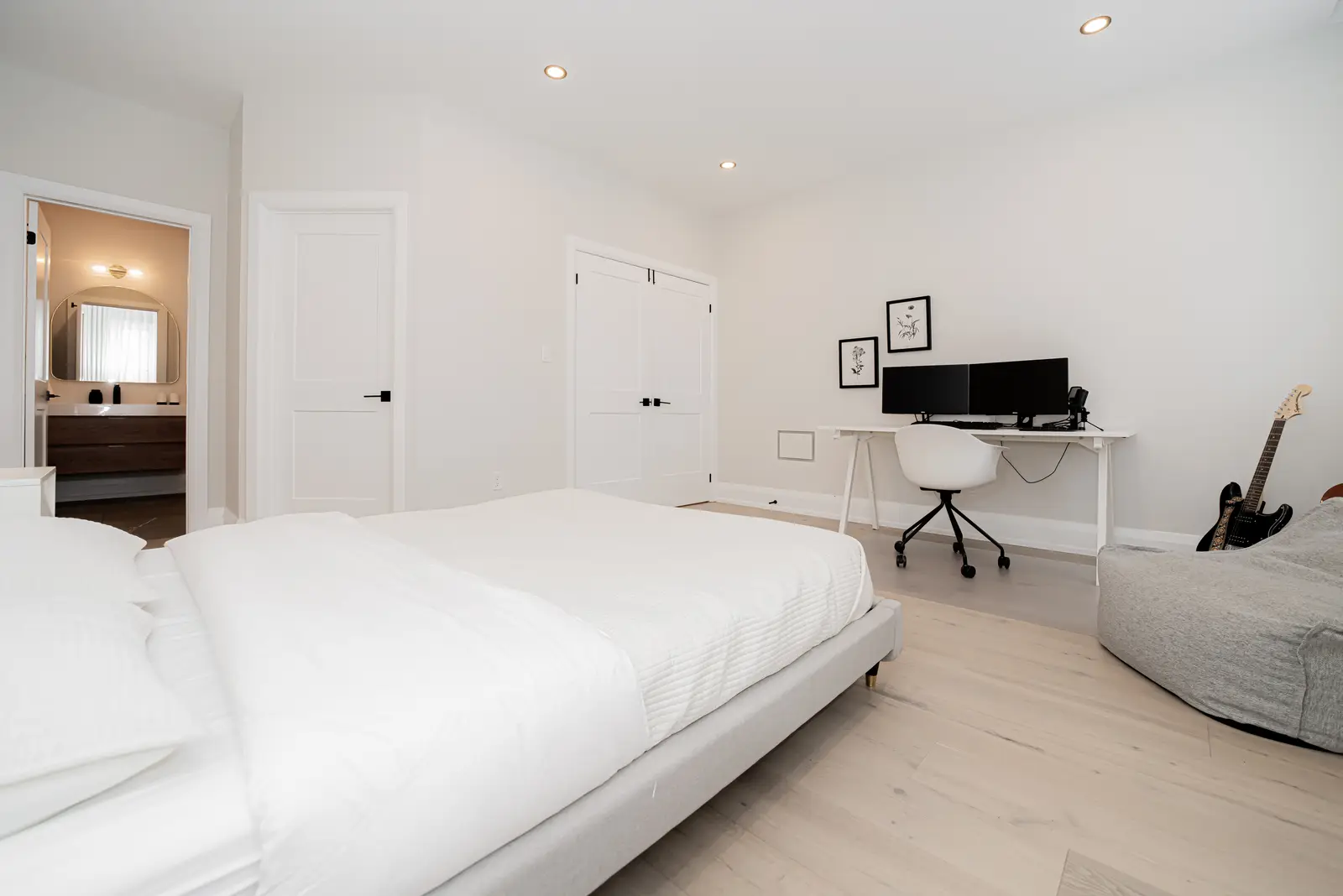 Interior of a Thornhill detached house renovation, with pale wood floors, black furnishings, and a walnut vanity in the primary bathroom.