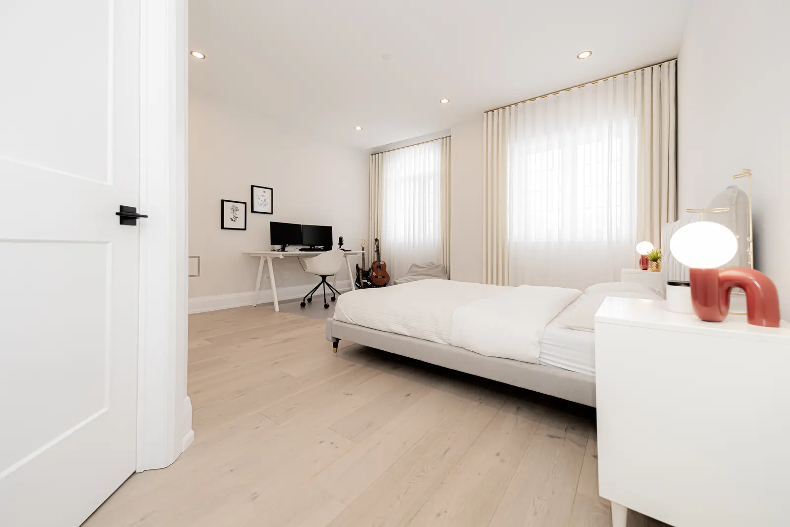 Interior of a Thornhill detached house renovation, with pale wood floors, black furnishings, and a walnut vanity in the primary bathroom.