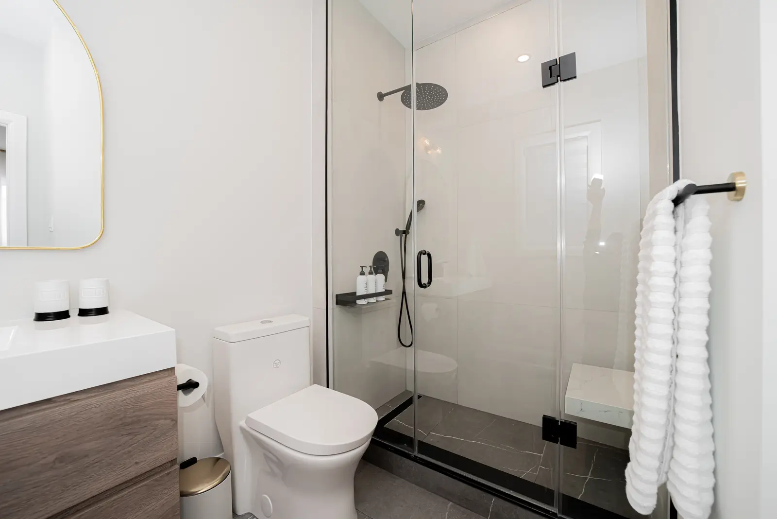 Interior of a Thornhill detached house renovation, with pale wood floors, black furnishings, and a walnut vanity in the primary bathroom.