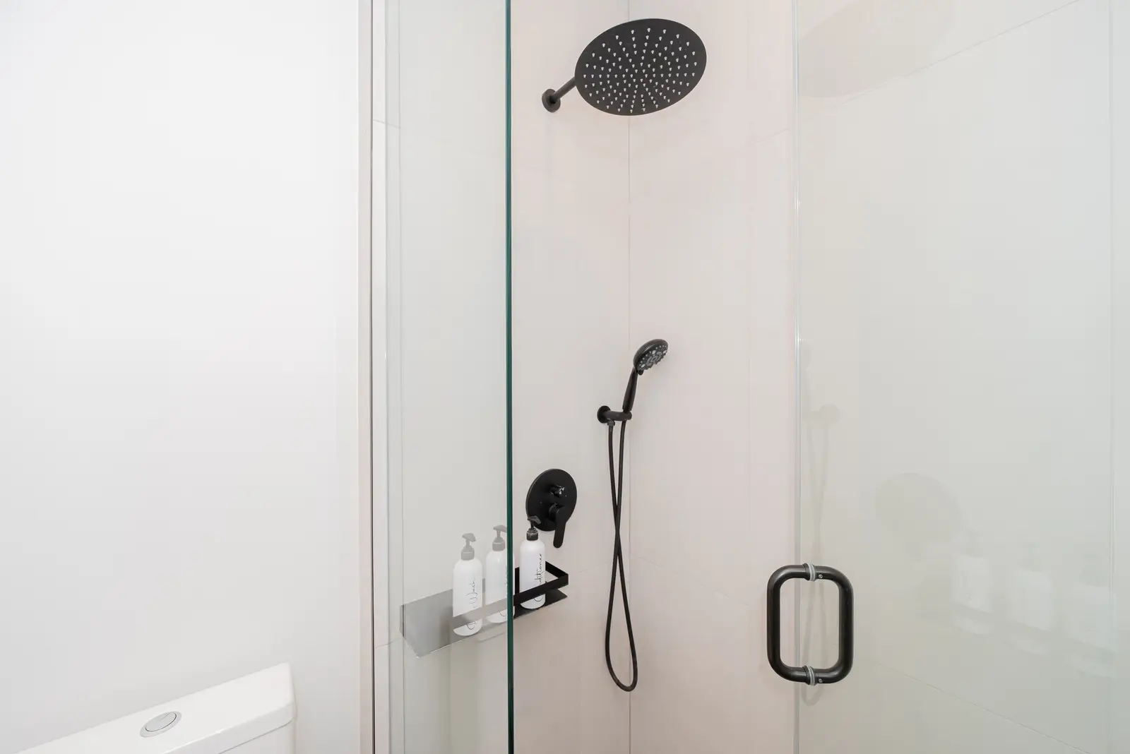Interior of a Thornhill detached house renovation, with pale wood floors, black furnishings, and a walnut vanity in the primary bathroom.