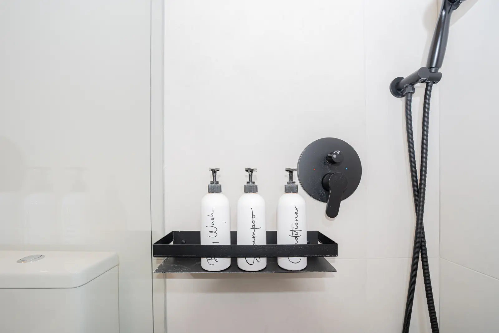Interior of a Thornhill detached house renovation, with pale wood floors, black furnishings, and a walnut vanity in the primary bathroom.