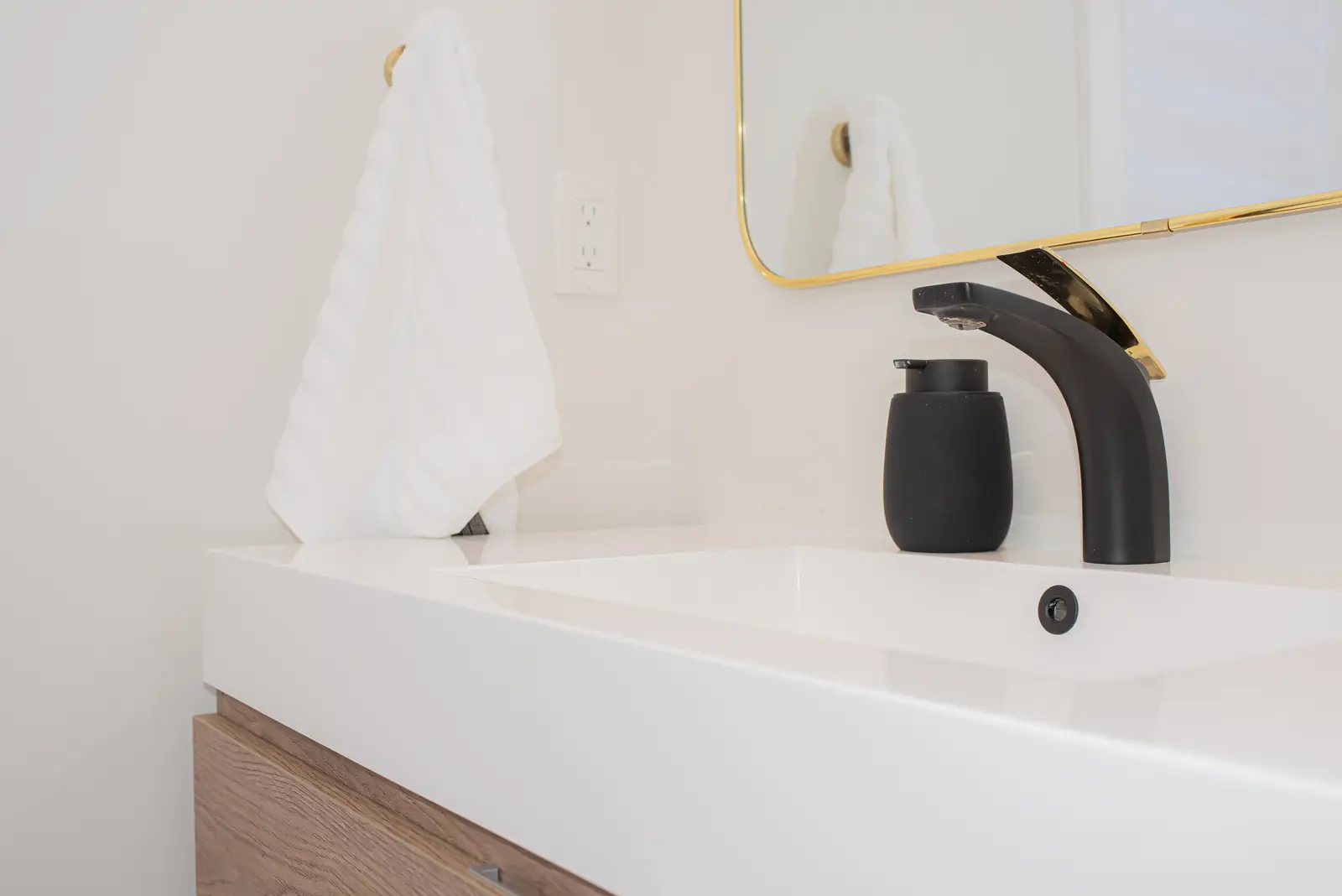 Interior of a Thornhill detached house renovation, with pale wood floors, black furnishings, and a walnut vanity in the primary bathroom.