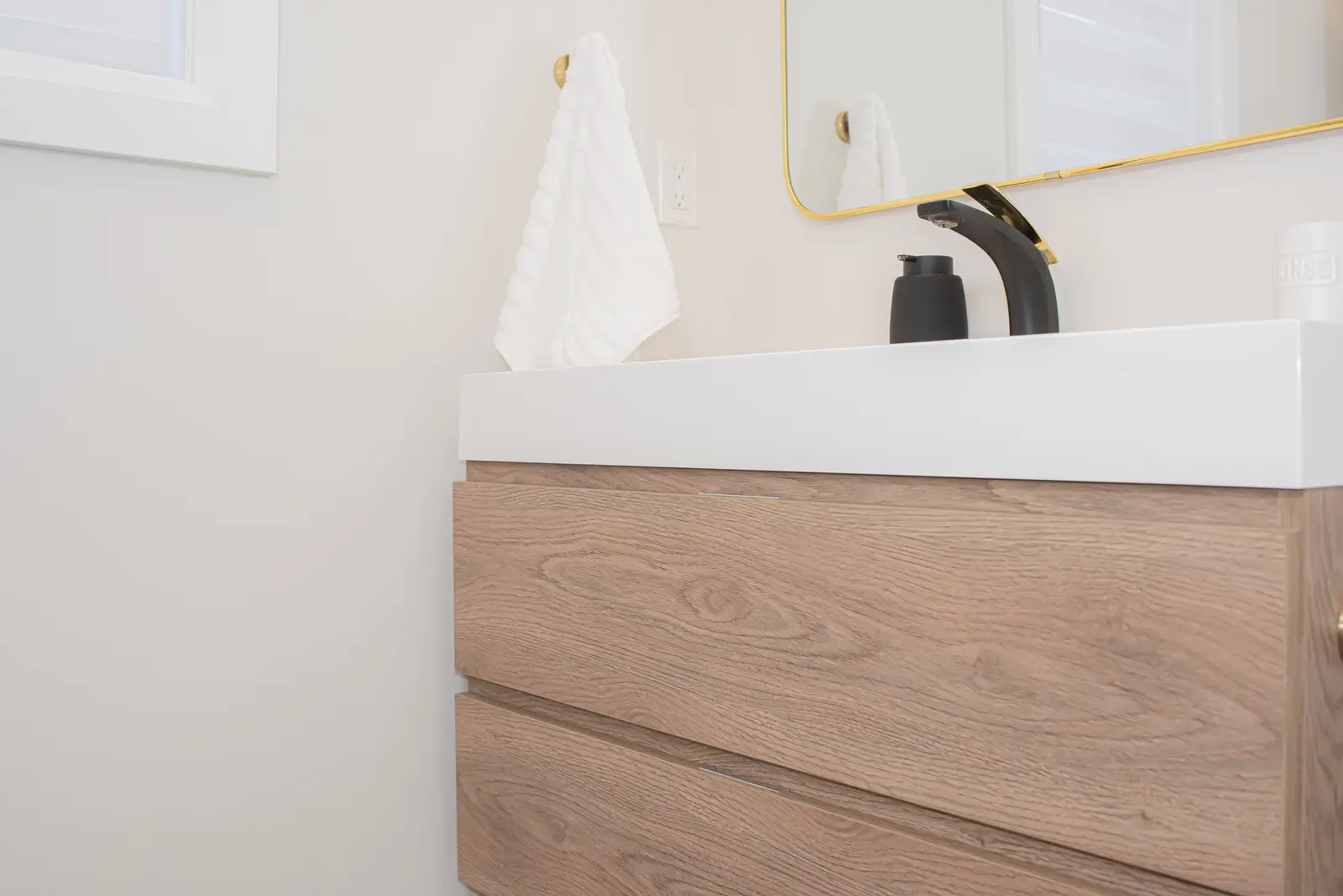 Interior of a Thornhill detached house renovation, with pale wood floors, black furnishings, and a walnut vanity in the primary bathroom.