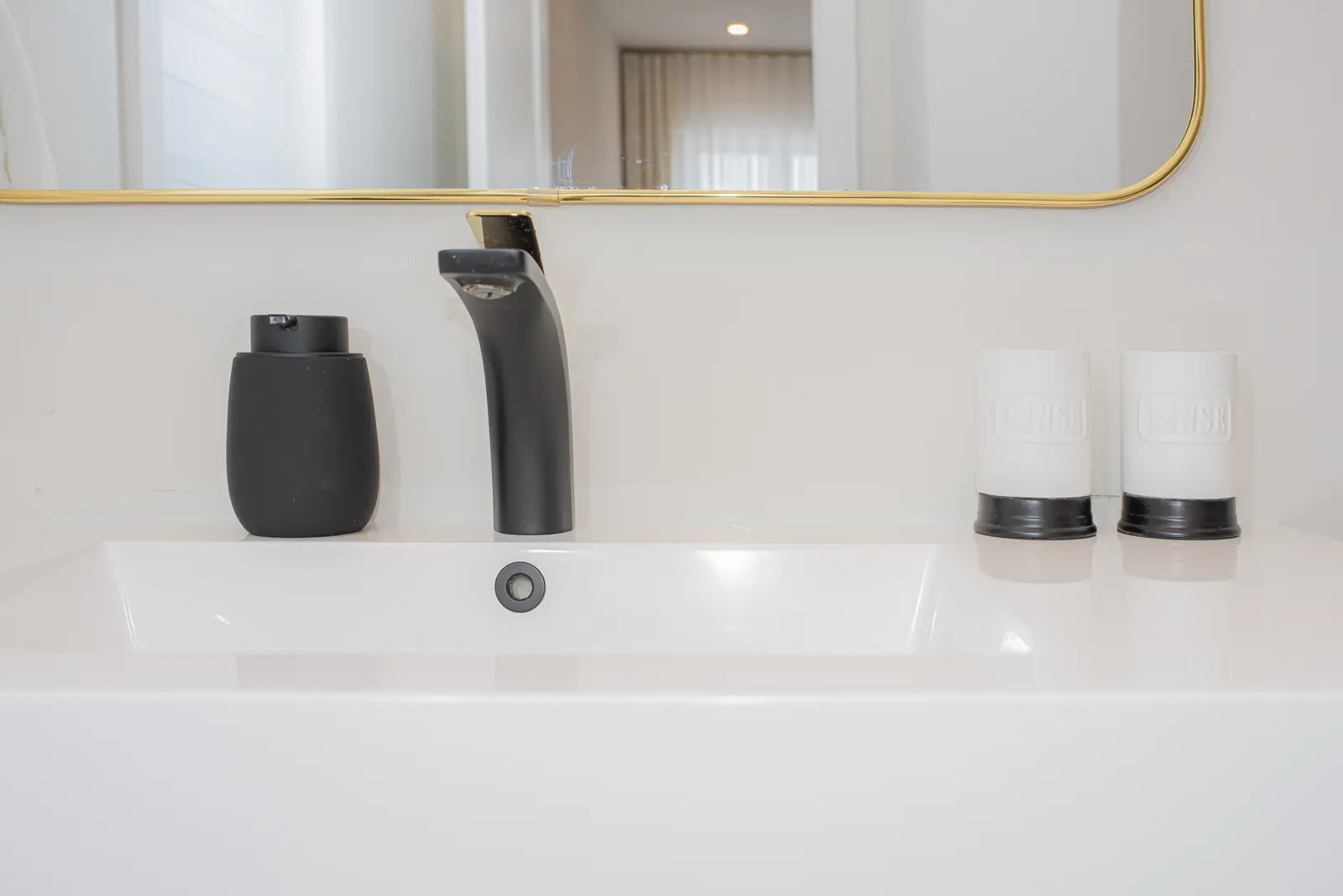Interior of a Thornhill detached house renovation, with pale wood floors, black furnishings, and a walnut vanity in the primary bathroom.