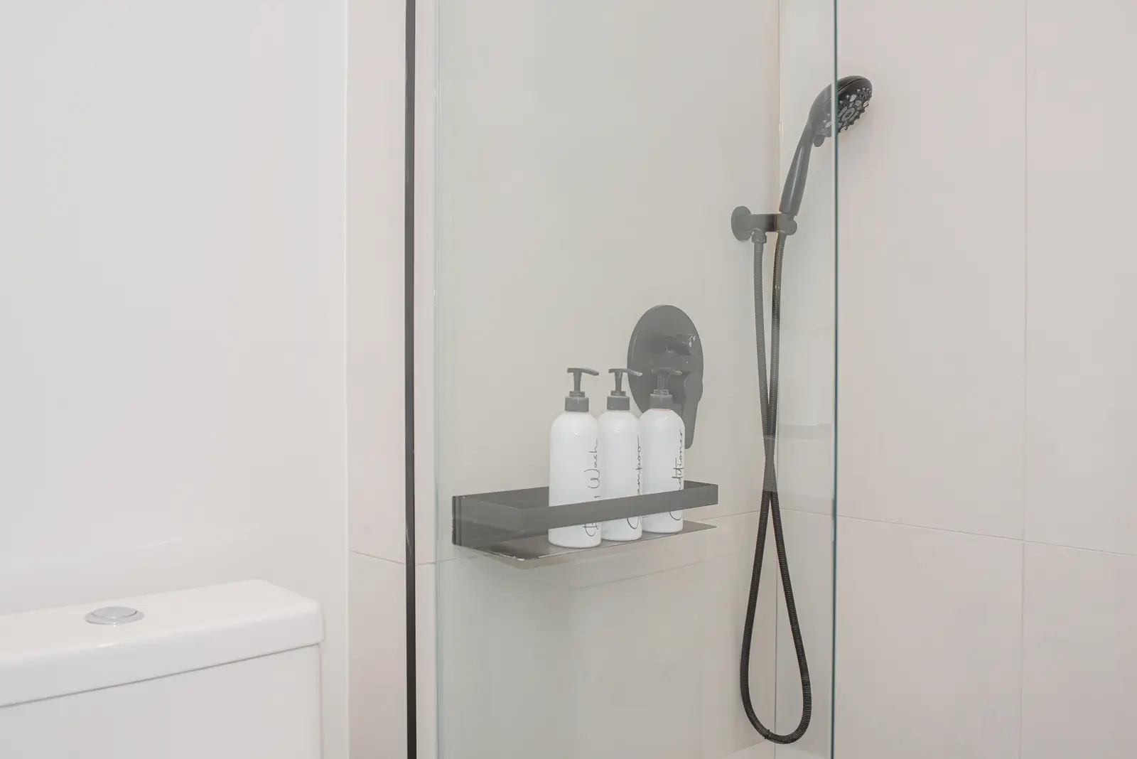Interior of a Thornhill detached house renovation, with pale wood floors, black furnishings, and a walnut vanity in the primary bathroom.
