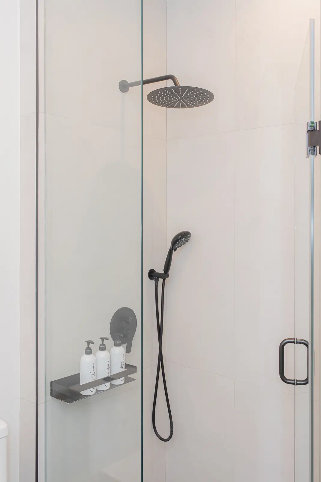 Interior of a Thornhill detached house renovation, with pale wood floors, black furnishings, and a walnut vanity in the primary bathroom.