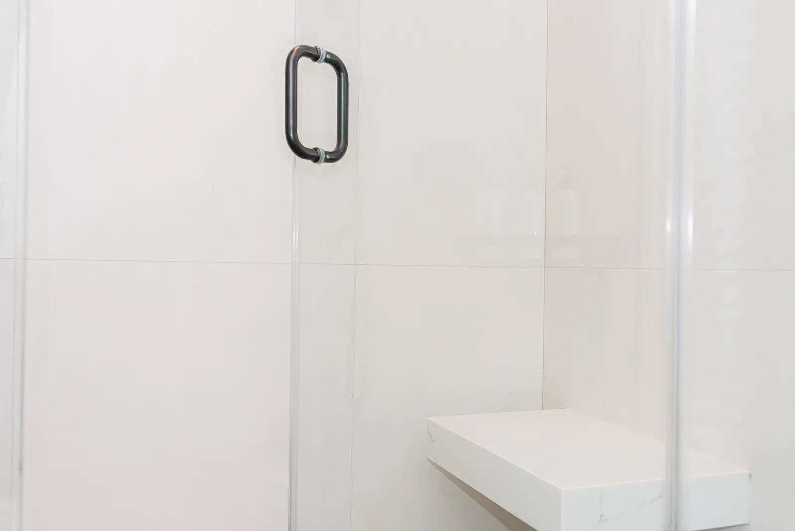Interior of a Thornhill detached house renovation, with pale wood floors, black furnishings, and a walnut vanity in the primary bathroom.