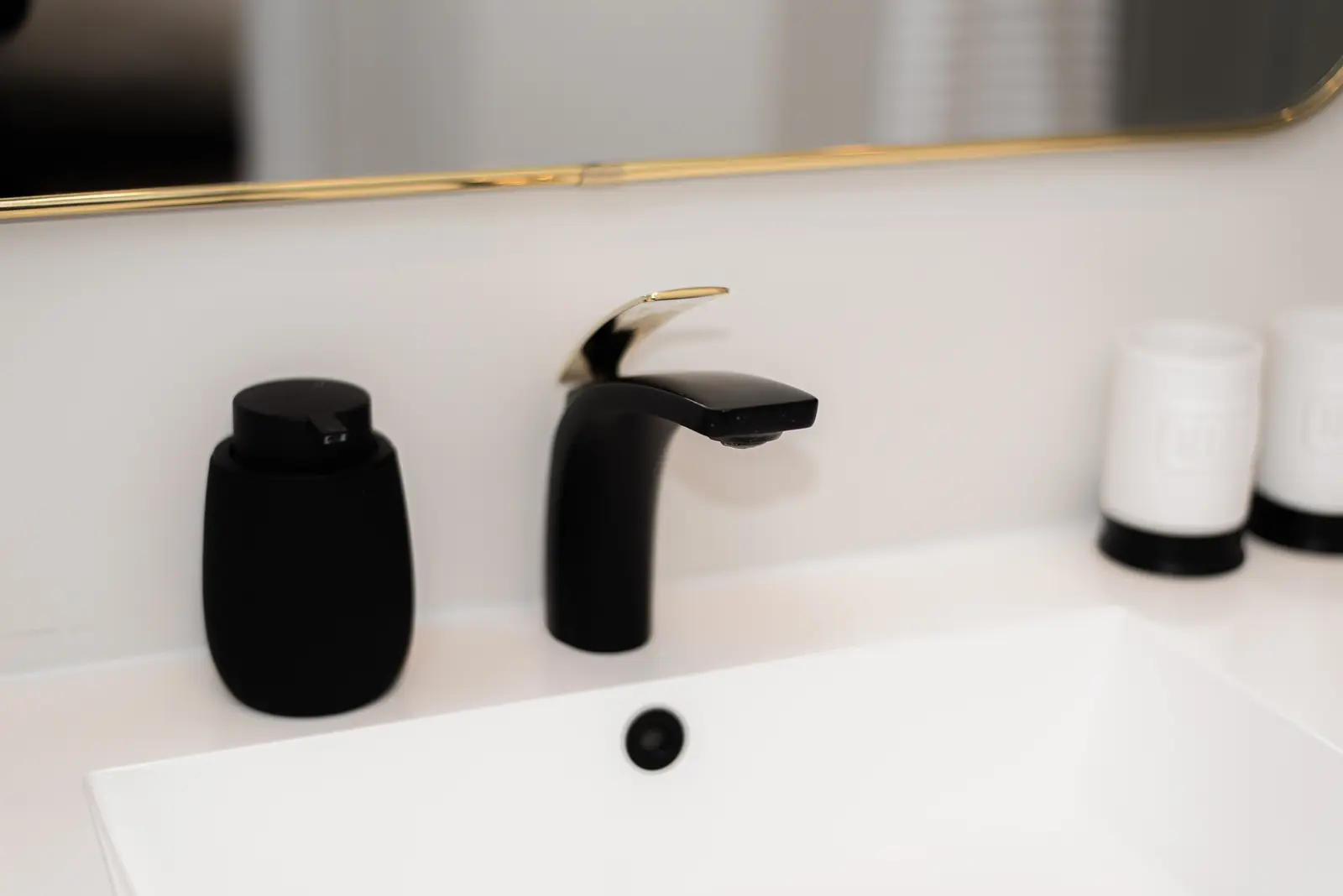 Interior of a Thornhill detached house renovation, with pale wood floors, black furnishings, and a walnut vanity in the primary bathroom.