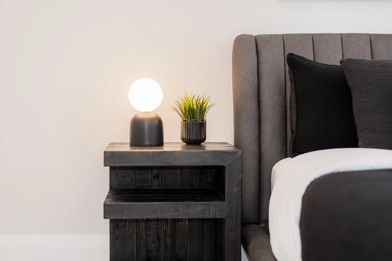 Interior of a Thornhill detached house renovation, with pale wood floors, black furnishings, and a walnut vanity in the primary bathroom.