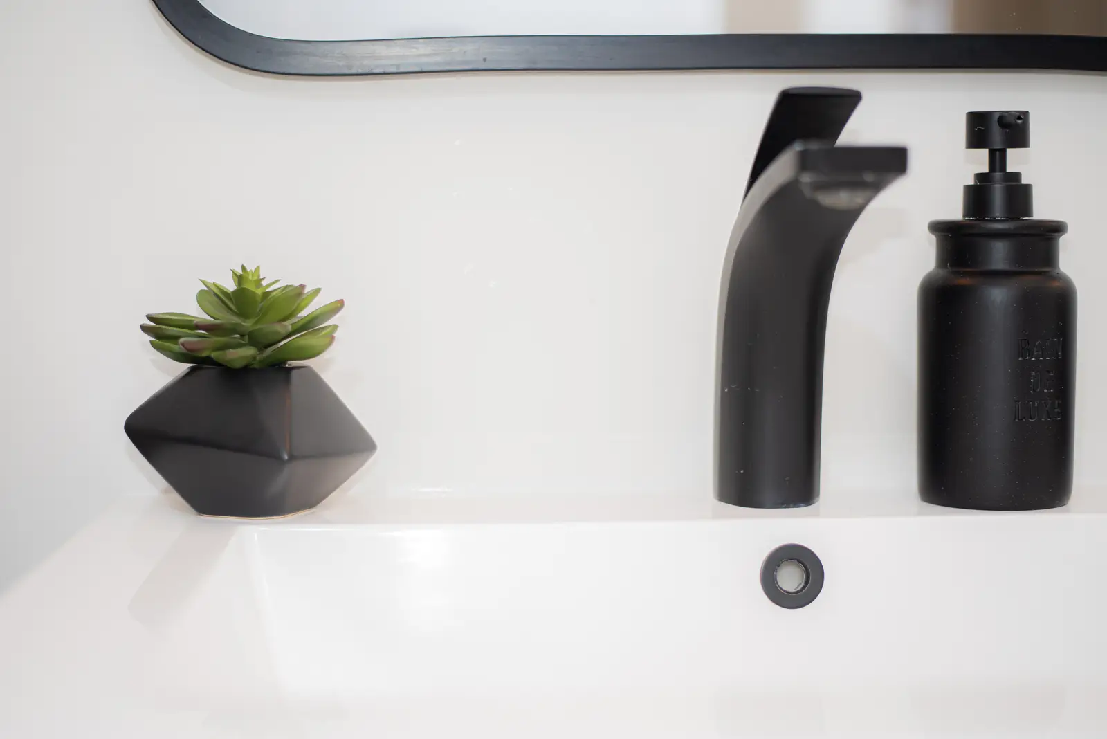 Interior of a Thornhill detached house renovation, with pale wood floors, black furnishings, and a walnut vanity in the primary bathroom.