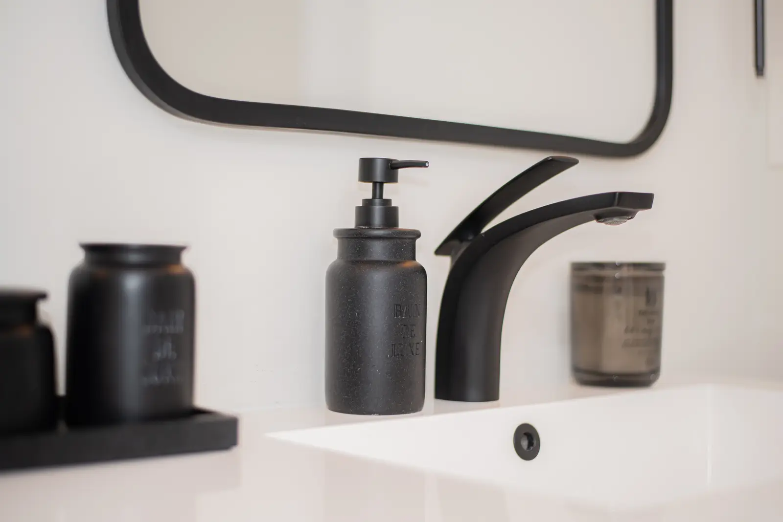 Interior of a Thornhill detached house renovation, with pale wood floors, black furnishings, and a walnut vanity in the primary bathroom.