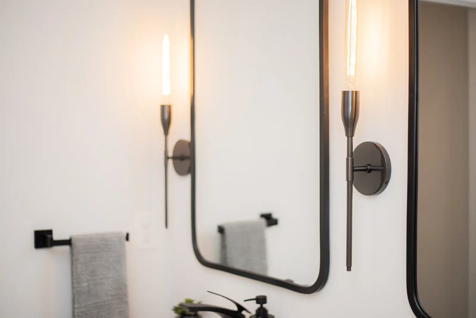 Interior of a Thornhill detached house renovation, with pale wood floors, black furnishings, and a walnut vanity in the primary bathroom.