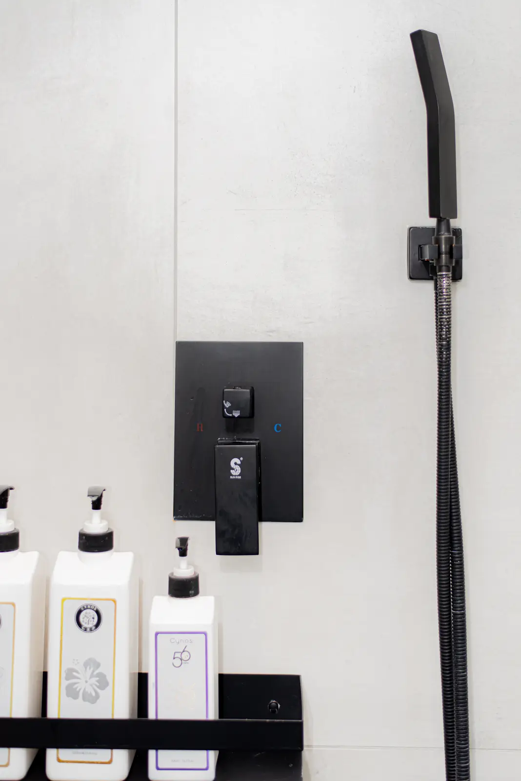 Interior of a Thornhill detached house renovation, with pale wood floors, black furnishings, and a walnut vanity in the primary bathroom.