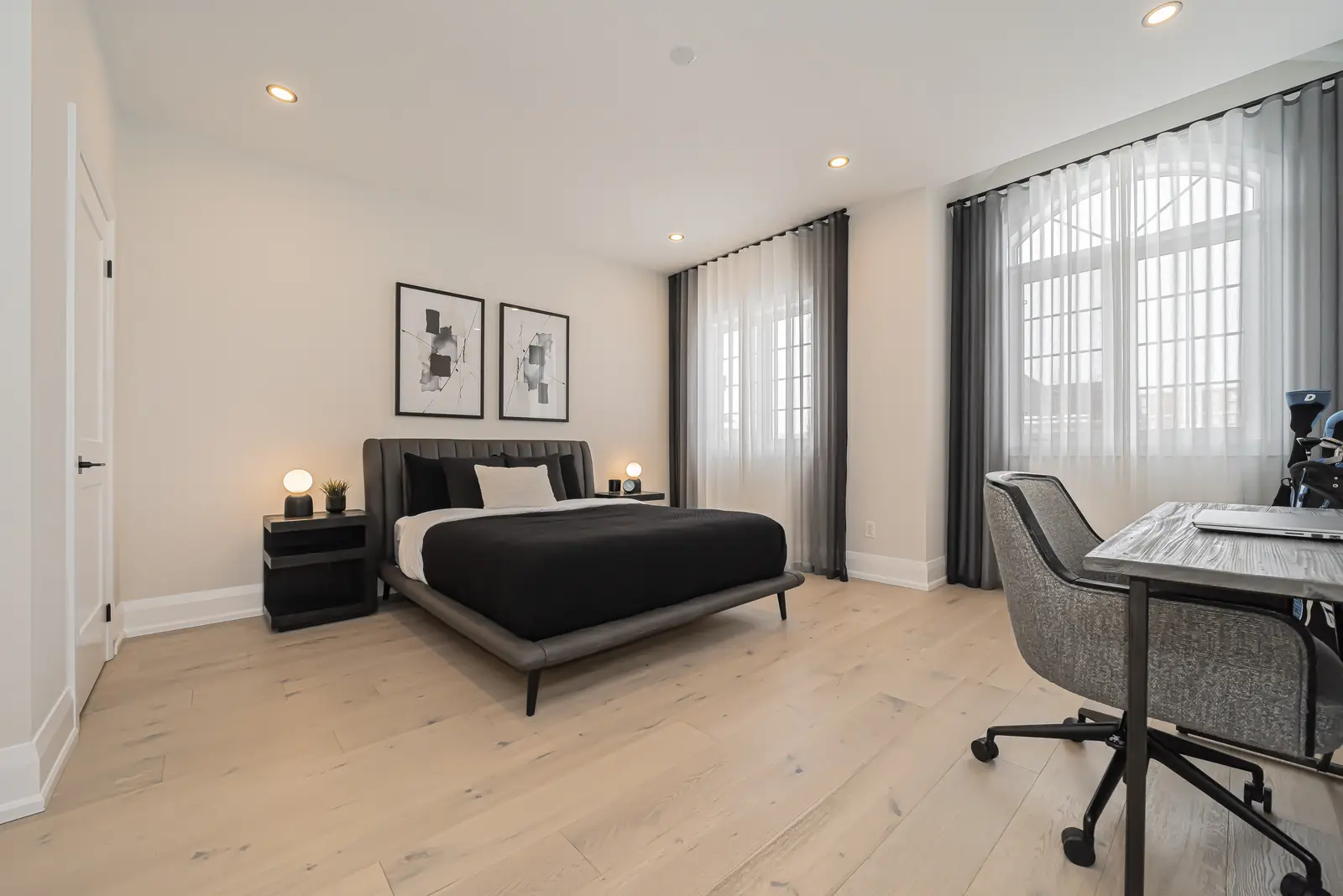 Interior of a Thornhill detached house renovation, with pale wood floors, black furnishings, and a walnut vanity in the primary bathroom.