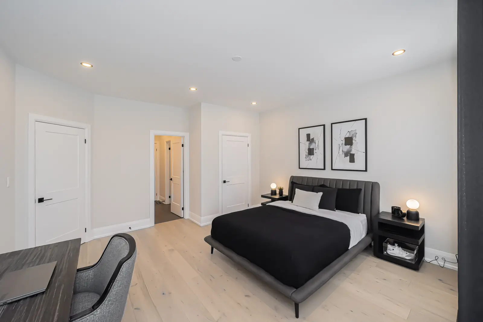 Interior of a Thornhill detached house renovation, with pale wood floors, black furnishings, and a walnut vanity in the primary bathroom.