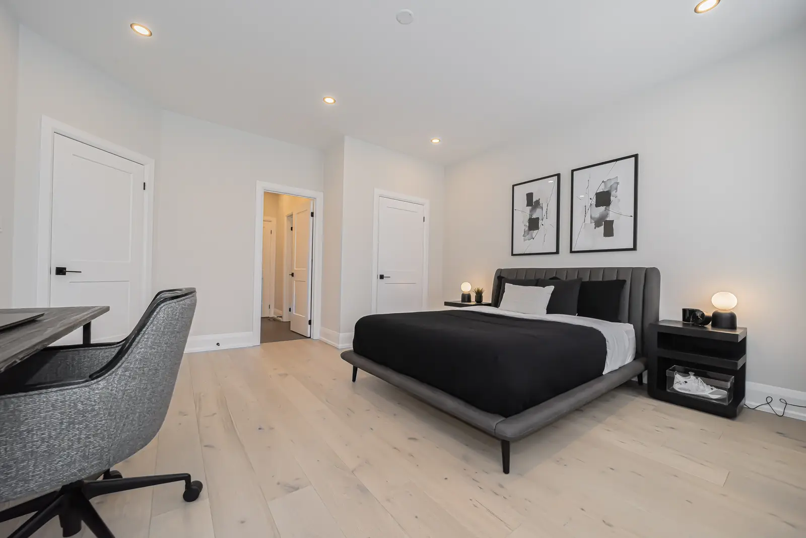 Interior of a Thornhill detached house renovation, with pale wood floors, black furnishings, and a walnut vanity in the primary bathroom.