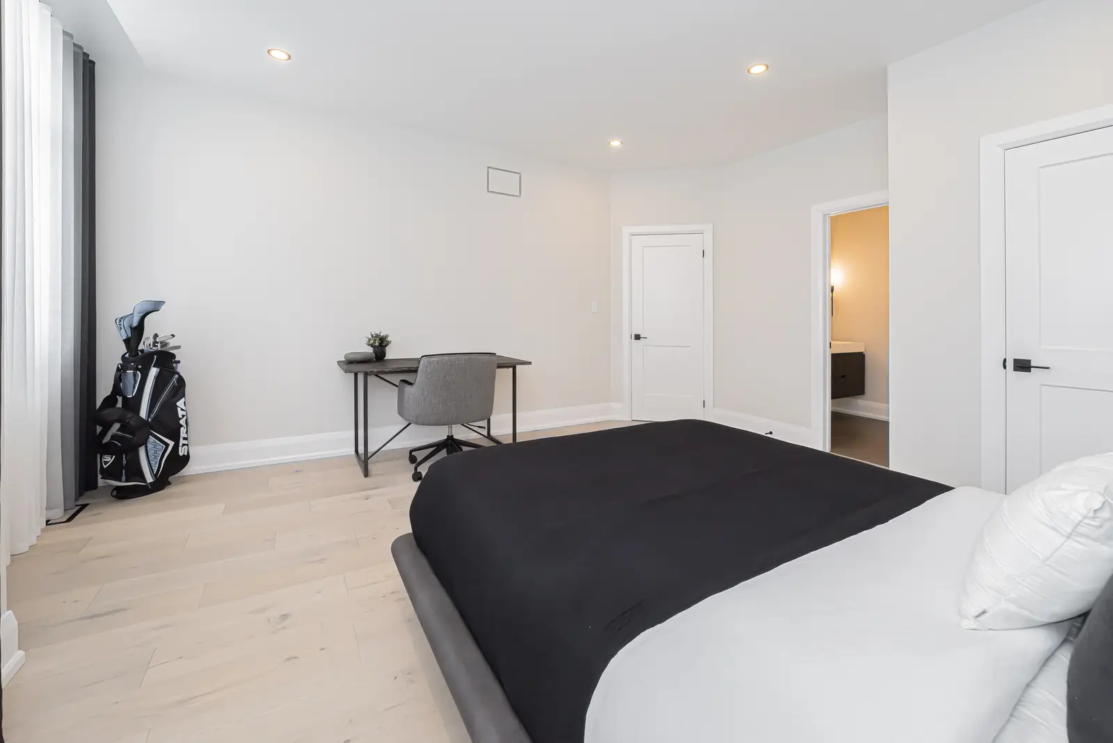 Interior of a Thornhill detached house renovation, with pale wood floors, black furnishings, and a walnut vanity in the primary bathroom.