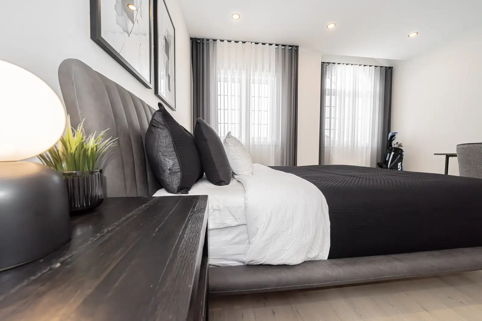 Interior of a Thornhill detached house renovation, with pale wood floors, black furnishings, and a walnut vanity in the primary bathroom.
