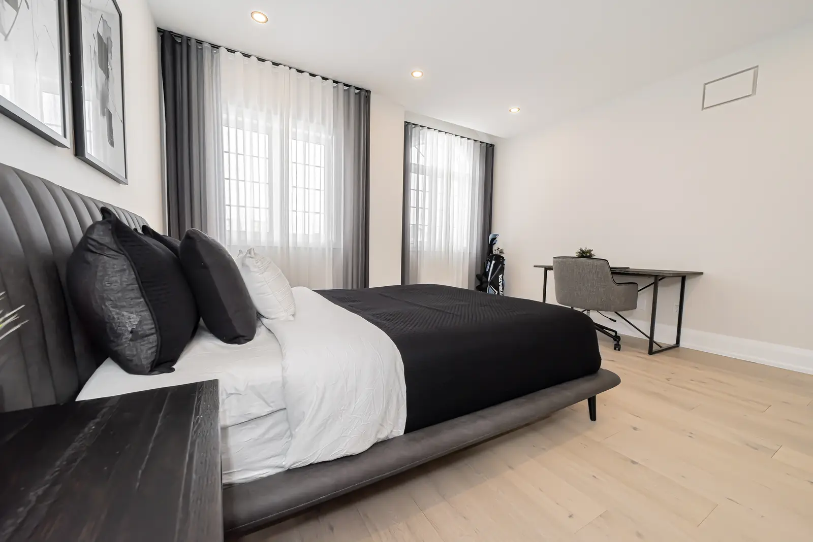 Interior of a Thornhill detached house renovation, with pale wood floors, black furnishings, and a walnut vanity in the primary bathroom.