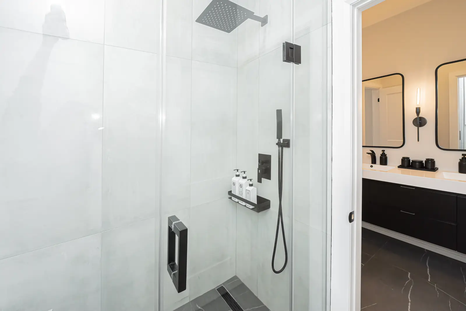 Interior of a Thornhill detached house renovation, with pale wood floors, black furnishings, and a walnut vanity in the primary bathroom.