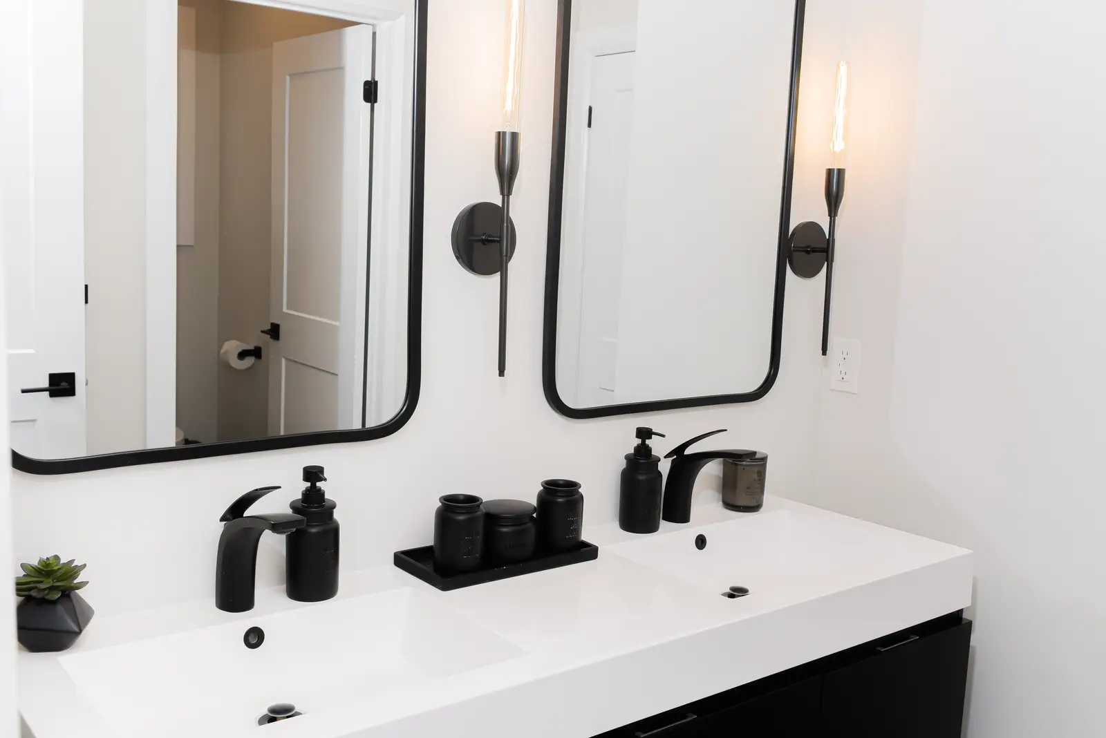 Interior of a Thornhill detached house renovation, with pale wood floors, black furnishings, and a walnut vanity in the primary bathroom.