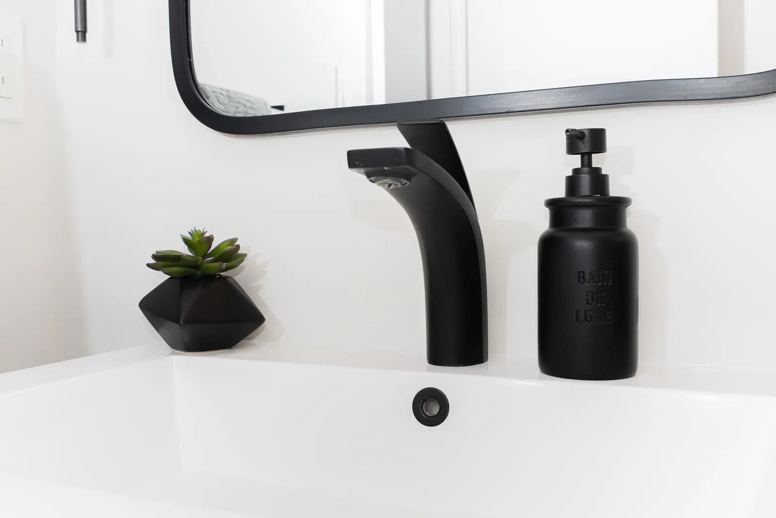 Interior of a Thornhill detached house renovation, with pale wood floors, black furnishings, and a walnut vanity in the primary bathroom.