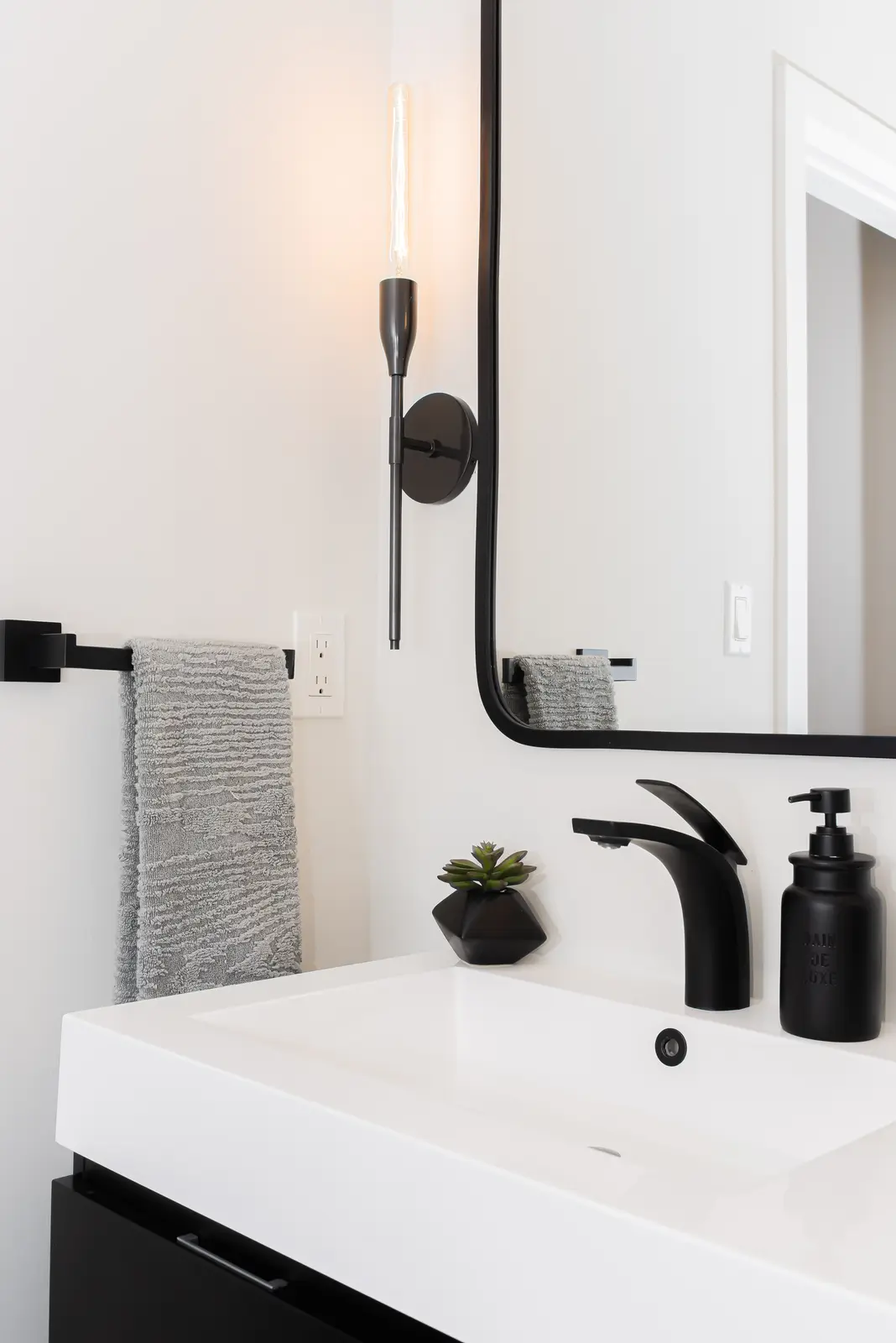 Interior of a Thornhill detached house renovation, with pale wood floors, black furnishings, and a walnut vanity in the primary bathroom.