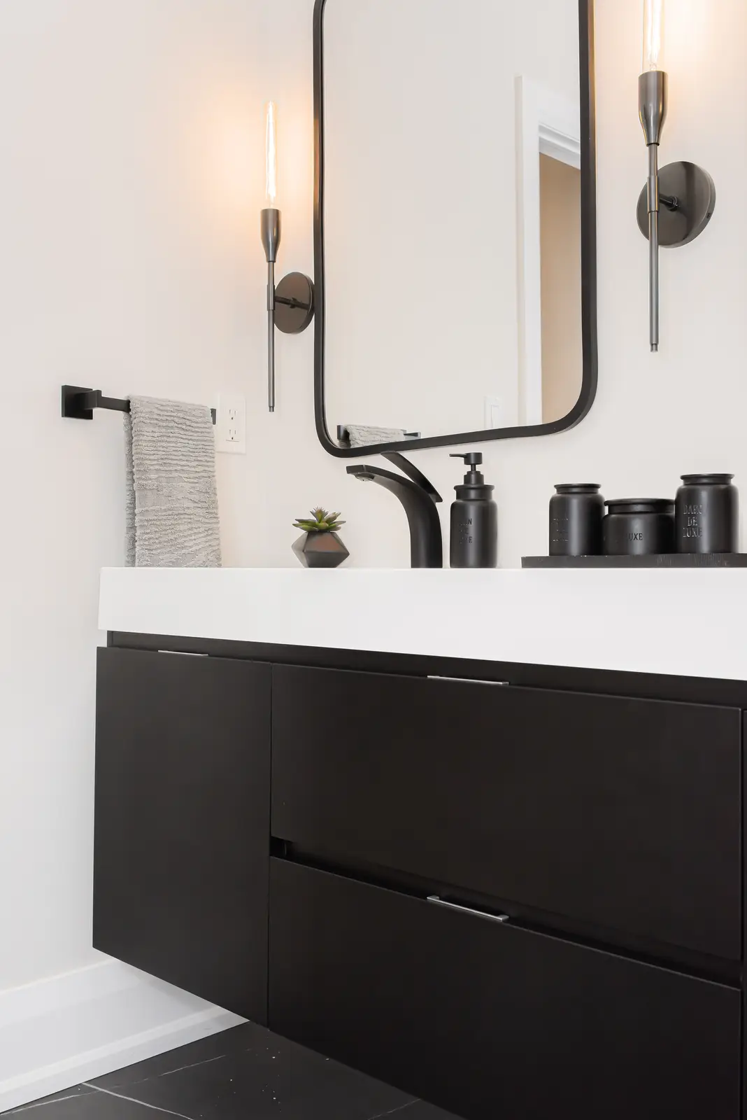 Black double vanity in a Thornhill detached house, with white counters, black fittings, and framed mirrors.