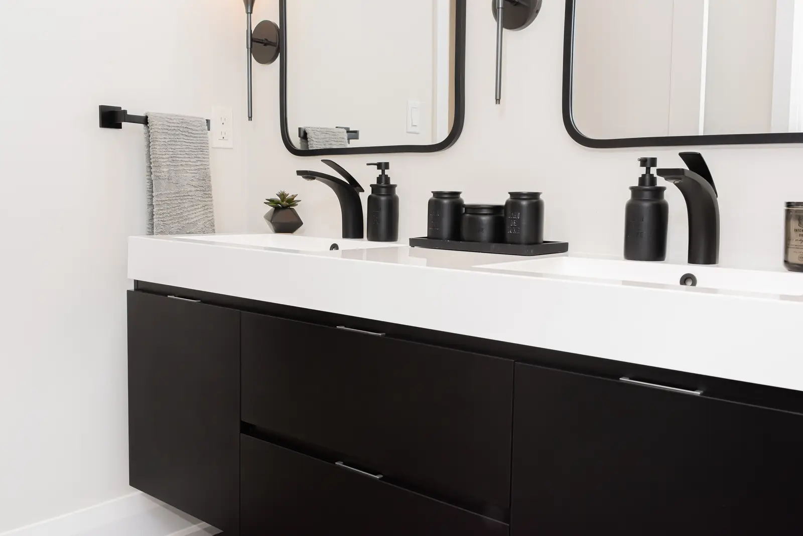 Interior of a Thornhill detached house renovation, with pale wood floors, black furnishings, and a walnut vanity in the primary bathroom.