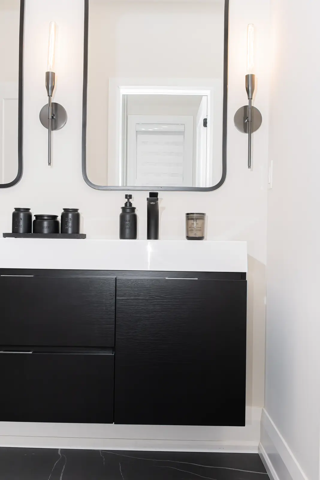 Interior of a Thornhill detached house renovation, with pale wood floors, black furnishings, and a walnut vanity in the primary bathroom.