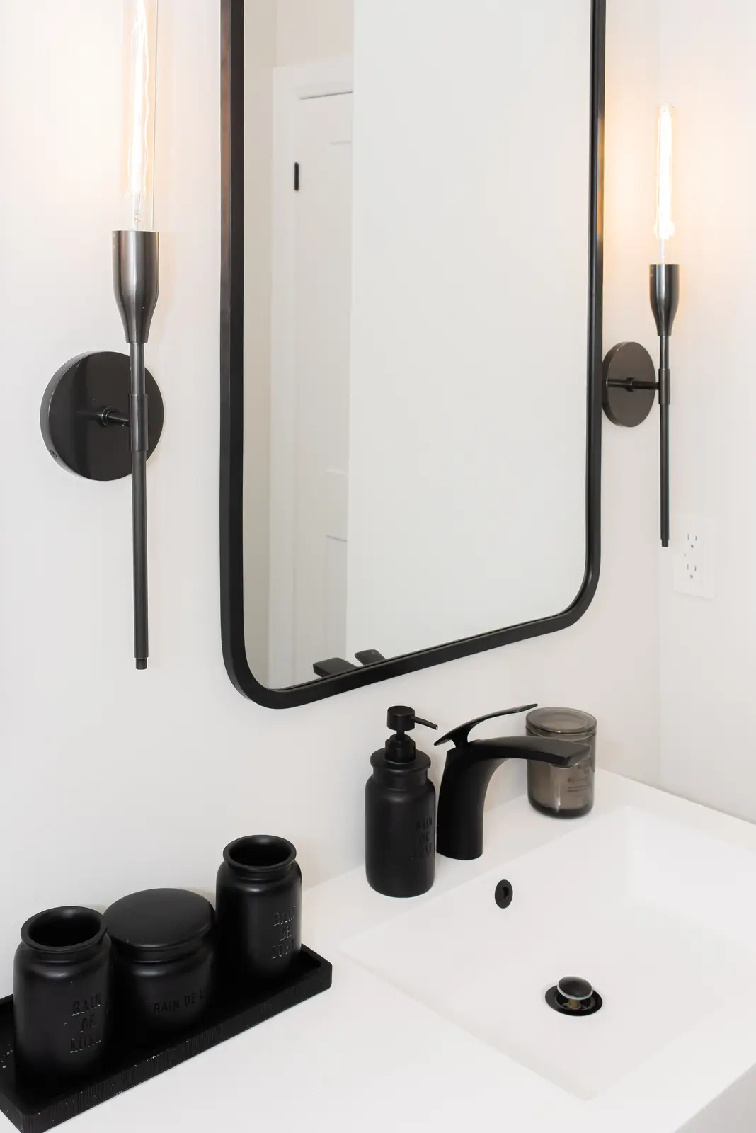 Interior of a Thornhill detached house renovation, with pale wood floors, black furnishings, and a walnut vanity in the primary bathroom.
