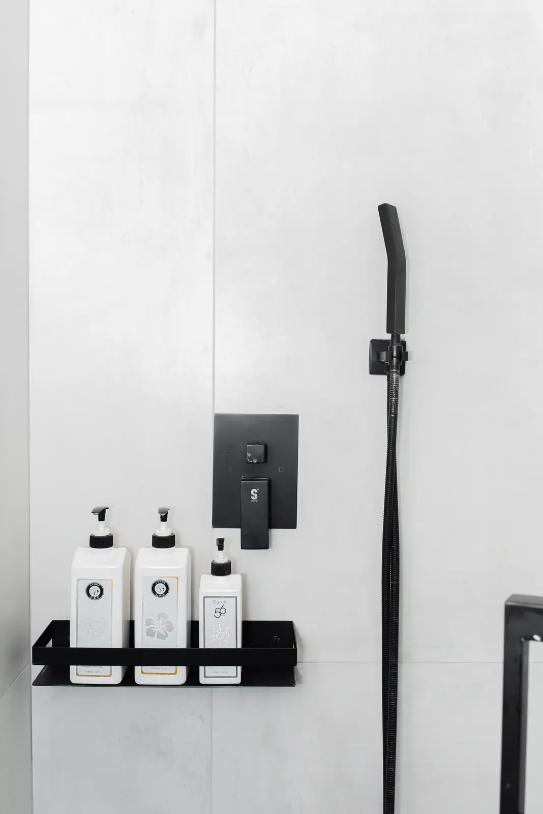 Interior of a Thornhill detached house renovation, with pale wood floors, black furnishings, and a walnut vanity in the primary bathroom.