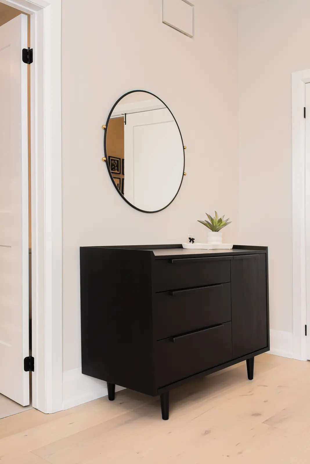 Interior of a Thornhill detached house renovation, with pale wood floors, black furnishings, and a walnut vanity in the primary bathroom.