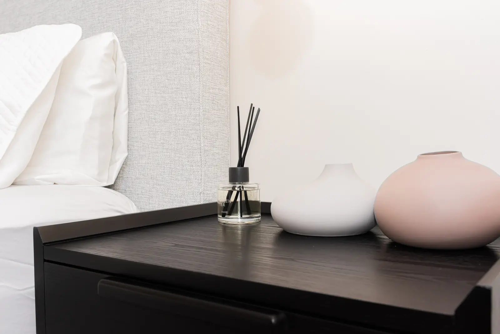 Interior of a Thornhill detached house renovation, with pale wood floors, black furnishings, and a walnut vanity in the primary bathroom.