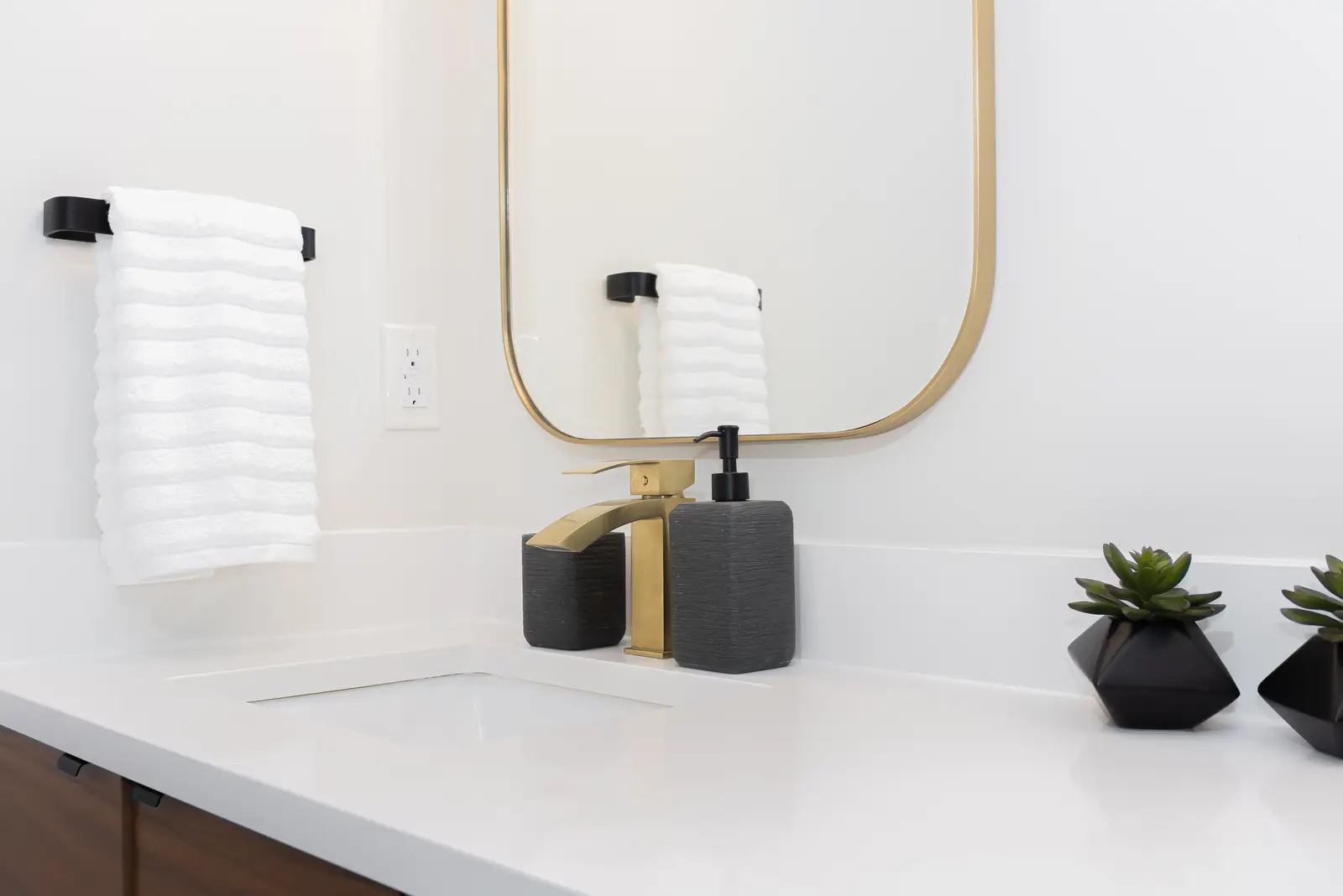 Interior of a Thornhill detached house renovation, with pale wood floors, black furnishings, and a walnut vanity in the primary bathroom.