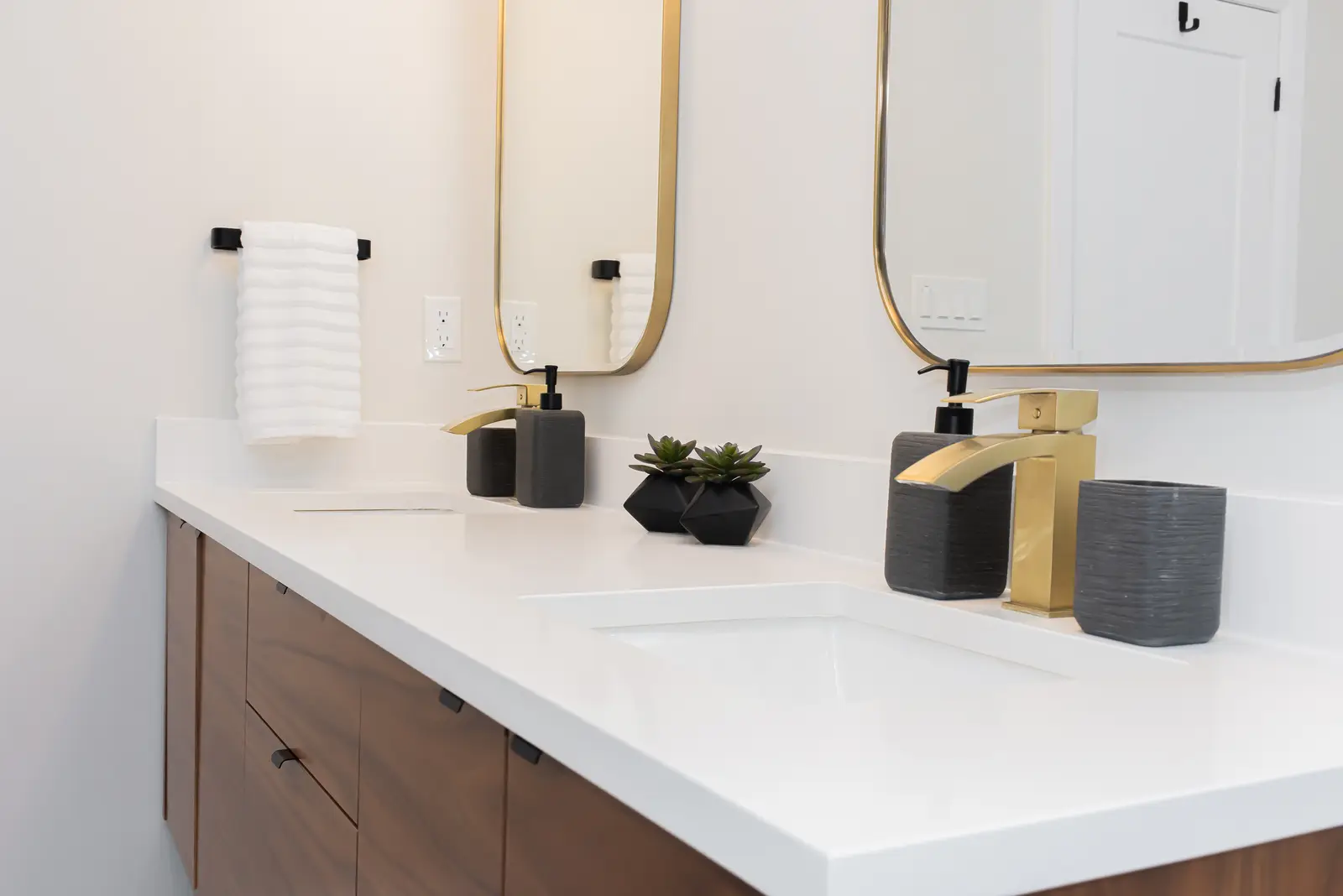 Interior of a Thornhill detached house renovation, with pale wood floors, black furnishings, and a walnut vanity in the primary bathroom.