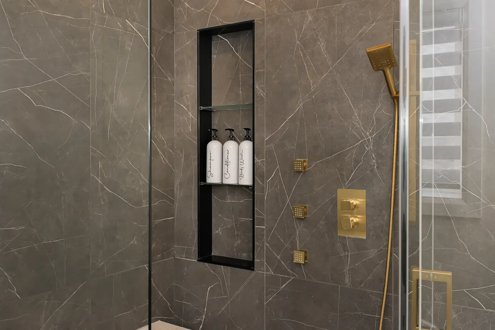 Interior of a Thornhill detached house renovation, with pale wood floors, black furnishings, and a walnut vanity in the primary bathroom.