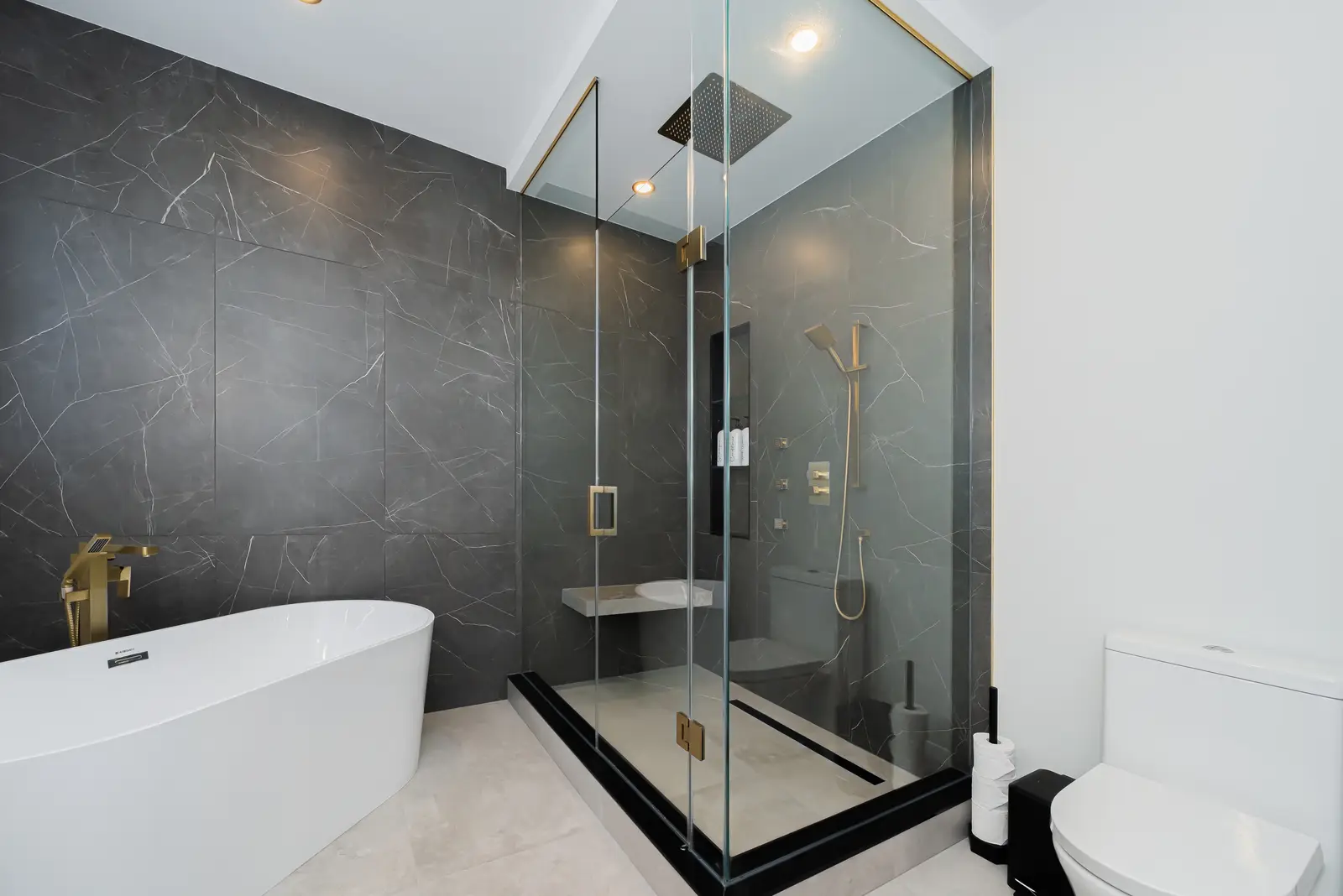 Interior of a Thornhill detached house renovation, with pale wood floors, black furnishings, and a walnut vanity in the primary bathroom.