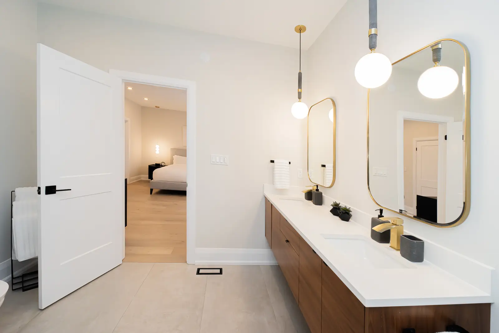 Interior of a Thornhill detached house renovation, with pale wood floors, black furnishings, and a walnut vanity in the primary bathroom.