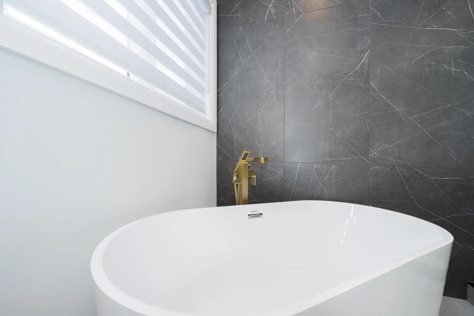 Interior of a Thornhill detached house renovation, with pale wood floors, black furnishings, and a walnut vanity in the primary bathroom.