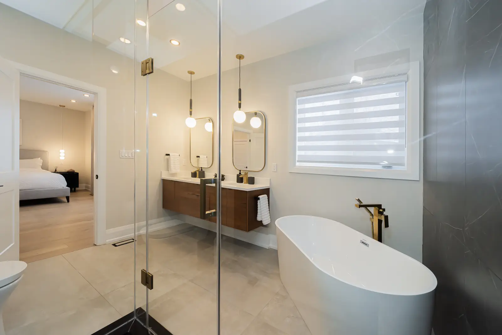 Interior of a Thornhill detached house renovation, with pale wood floors, black furnishings, and a walnut vanity in the primary bathroom.