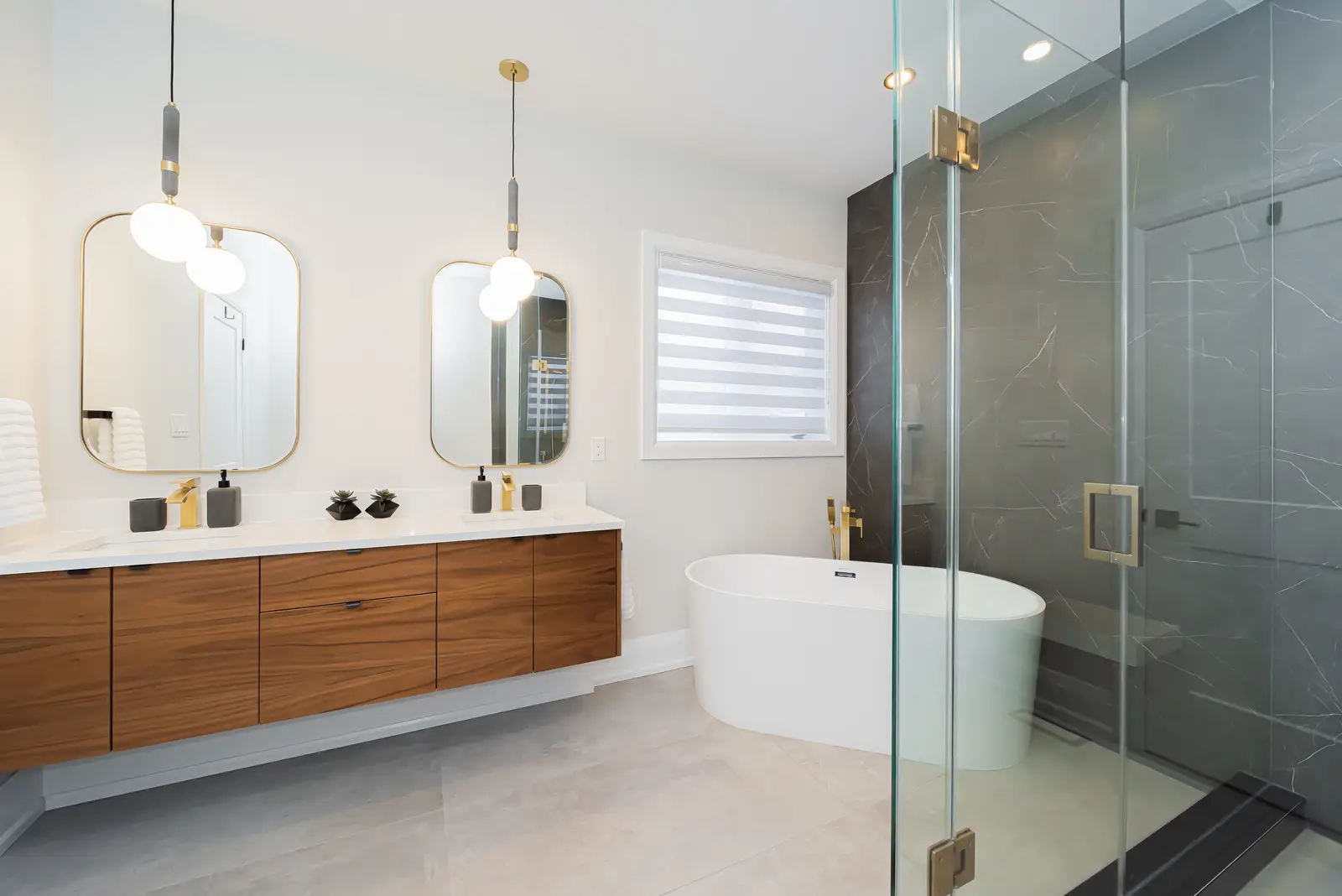 Interior of a Thornhill detached house renovation, with pale wood floors, black furnishings, and a walnut vanity in the primary bathroom.