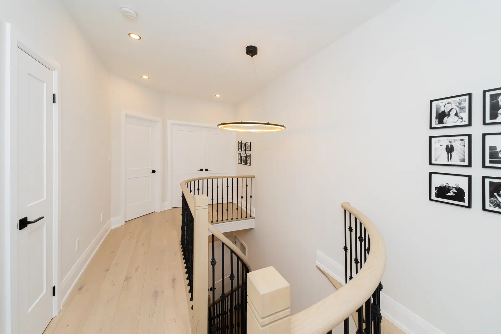 Interior of a Thornhill detached house renovation, with pale wood floors, black furnishings, and a walnut vanity in the primary bathroom.