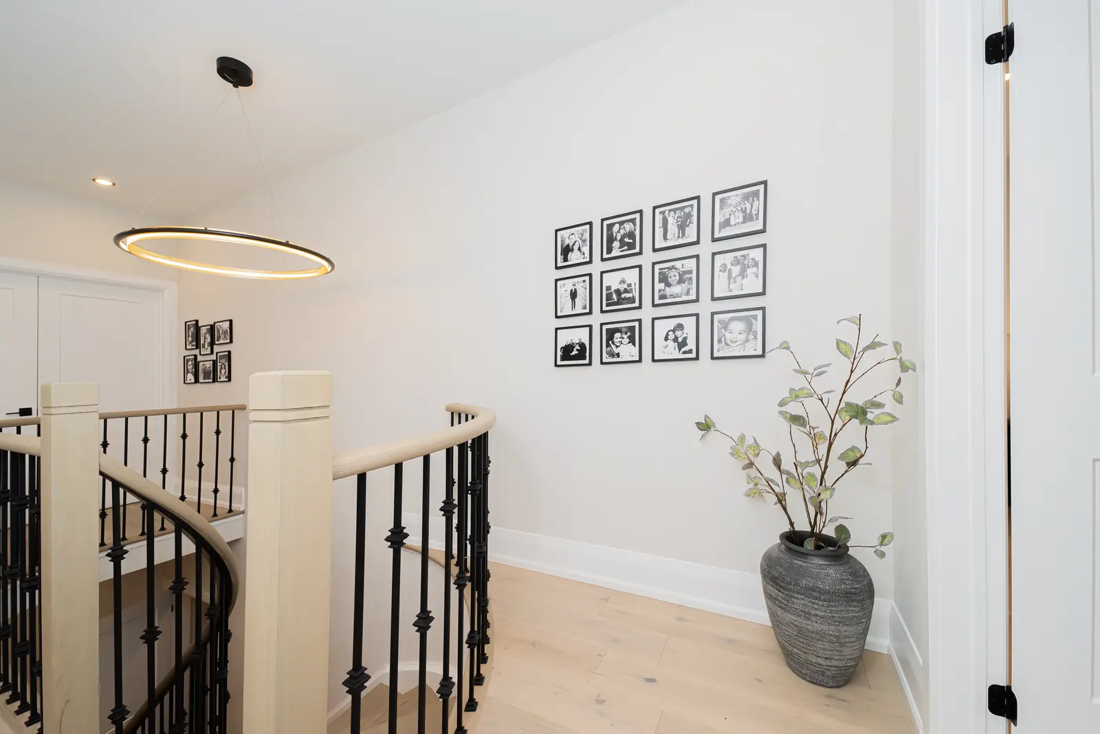 Interior of a Thornhill detached house renovation, with pale wood floors, black furnishings, and a walnut vanity in the primary bathroom.