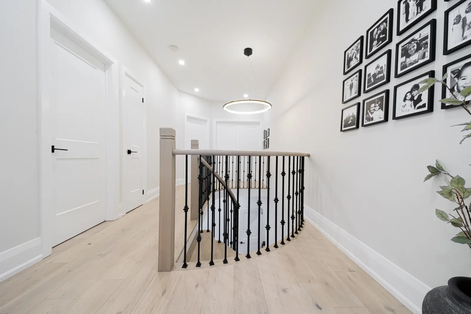 Interior of a Thornhill detached house renovation, with pale wood floors, black furnishings, and a walnut vanity in the primary bathroom.
